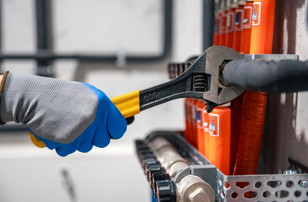 Pipe wrench on plumbing fittings during an urgent repair